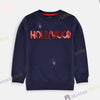 Girl wearing a navy blue sweatshirt with 'HOLLYWOOD' in red sequins on a light gray background