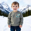 Child wearing a sweatshirt with a logo in a snowy mountain landscape