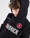 Person wearing a black tracksuit with 'Goodrich' branding on a white background