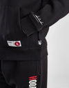 Person wearing a black tracksuit with 'Goodrich' branding on a white background