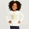 Young girl wearing a white long-sleeve top with a gold snowflake design on a plain background