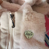 Young girl wearing a pink fur vest with a heart emblem on a light gray background