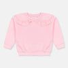 Young girl wearing a pink sweater with a lace collar in a snowy mountain setting