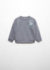 Child wearing a sweatshirt with a logo in a snowy mountain landscape