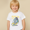 Child wearing a white t-shirt with a colorful shoe graphic and text on a beige background