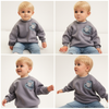 Child wearing a sweatshirt with a logo in a snowy mountain landscape