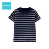 Baby wearing a navy and white striped shirt sitting on a white couch.